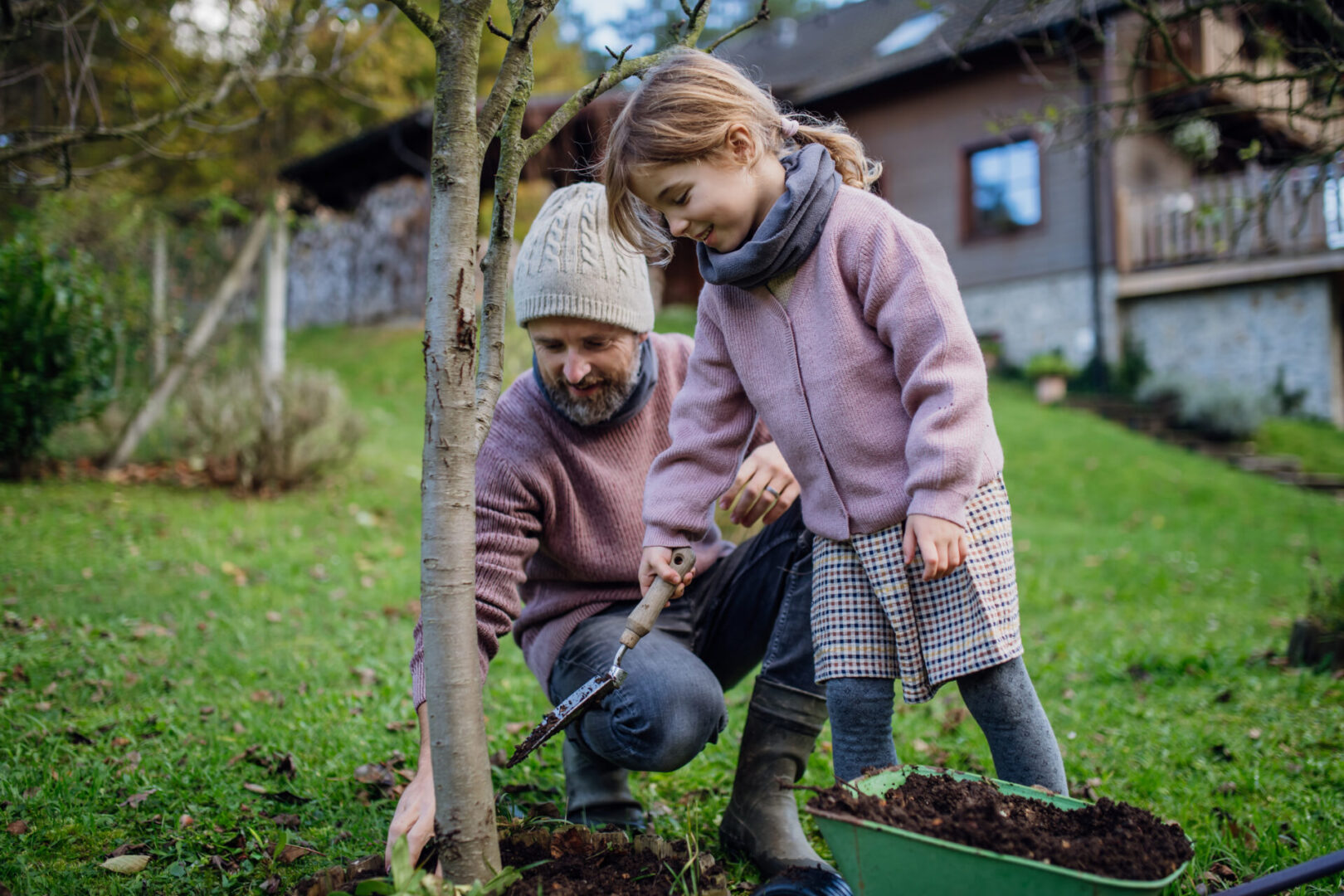 A man and girl are gardening in the yard.